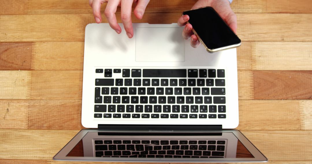 Person Using Laptop and Smartphone on Wooden Desk - Free Images, Stock Photos and Pictures on Pikwizard.com