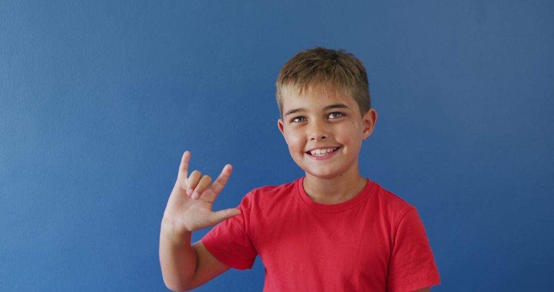 Young Boy Signing I Love You with Hand Gesture and Smile - Free Images, Stock Photos and Pictures on Pikwizard.com