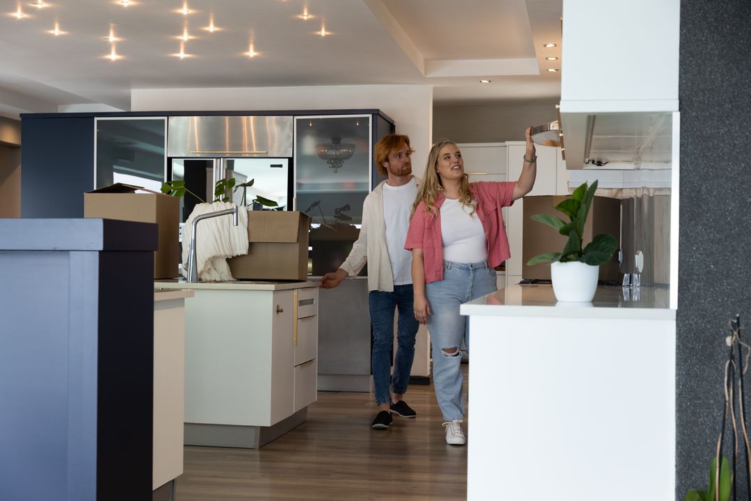 Couple Exploring New Home Kitchen With Moving Boxes