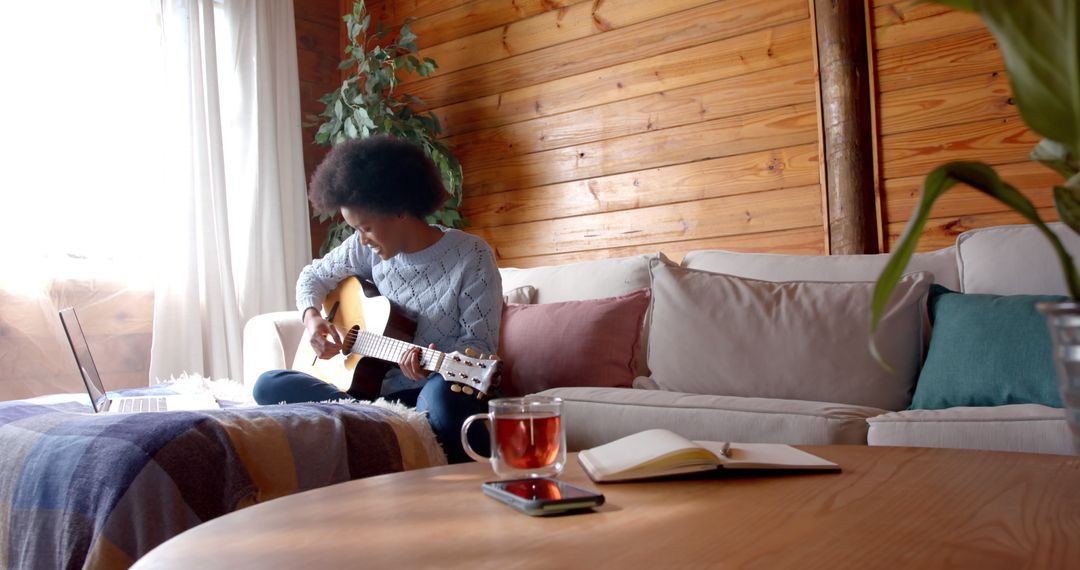 Young Woman Playing Guitar in Cozy Living Room - Free Images, Stock Photos and Pictures on Pikwizard.com