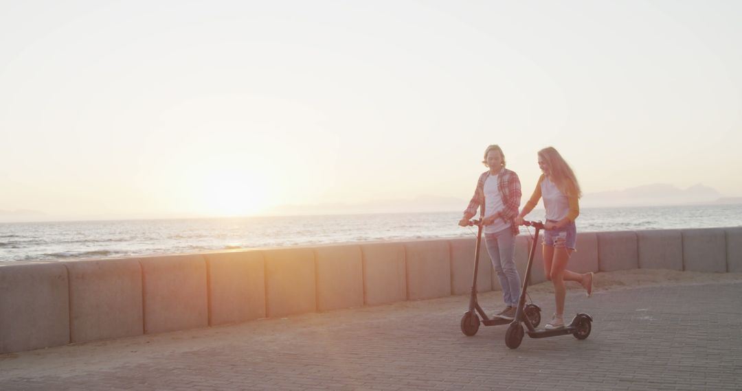 Young Women Riding Electric Scooters Along Sunset Beach Path - Free Images, Stock Photos and Pictures on Pikwizard.com