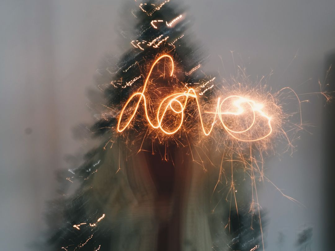 Love Sparkler Writing in Front of Christmas Tree - Free Images, Stock Photos and Pictures on Pikwizard.com