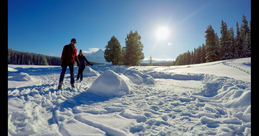 Couple Hiking in Snowy Wilderness Under Clear Blue Sky