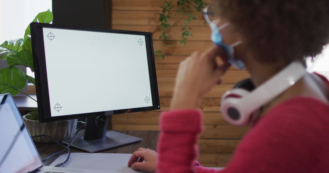 Person Analyzing Information on Computer Monitor Wearing a Face Mask - Free Images, Stock Photos and Pictures on Pikwizard.com