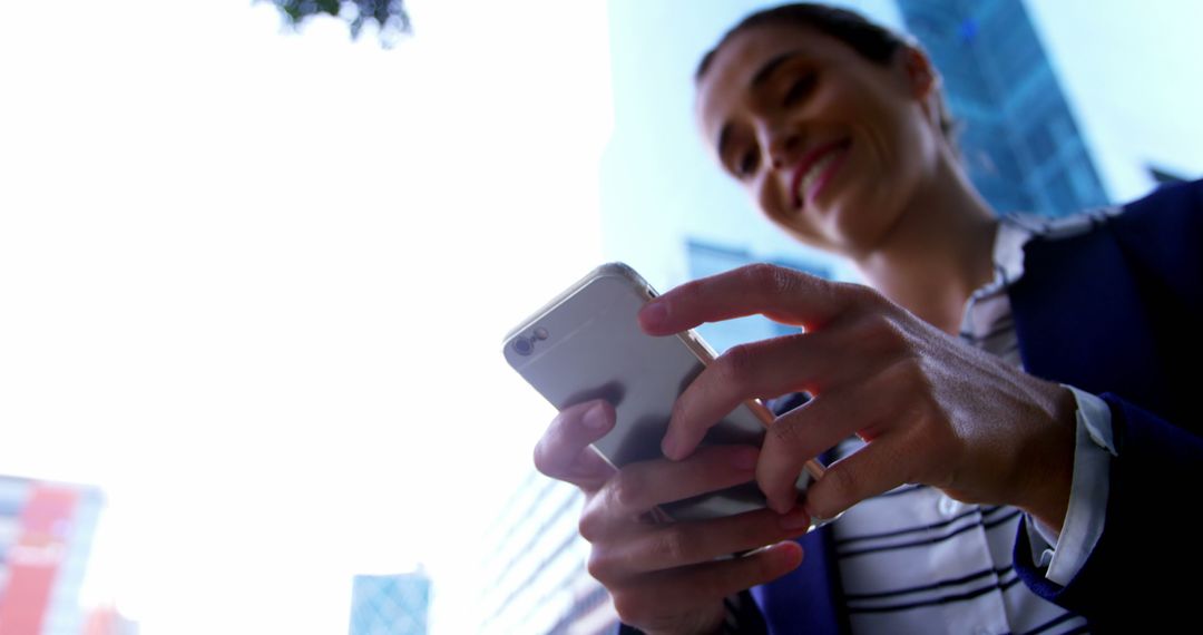 Businesswoman Checking Smartphone Outdoors in Urban Cityscape - Free Images, Stock Photos and Pictures on Pikwizard.com