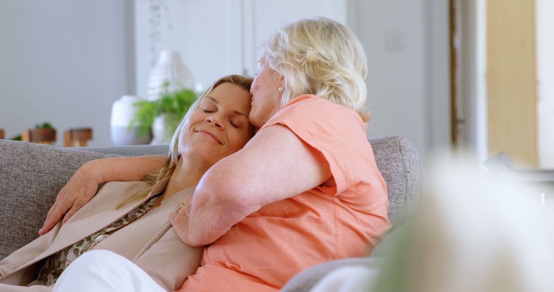 Loving Senior Woman Embracing Adult Daughter on Sofa in Cozy Living Room - Free Images, Stock Photos and Pictures on Pikwizard.com