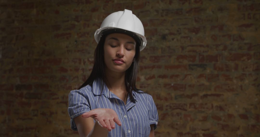 Female Construction Worker Checking Palm in Front of Brick Wall - Free Images, Stock Photos and Pictures on Pikwizard.com