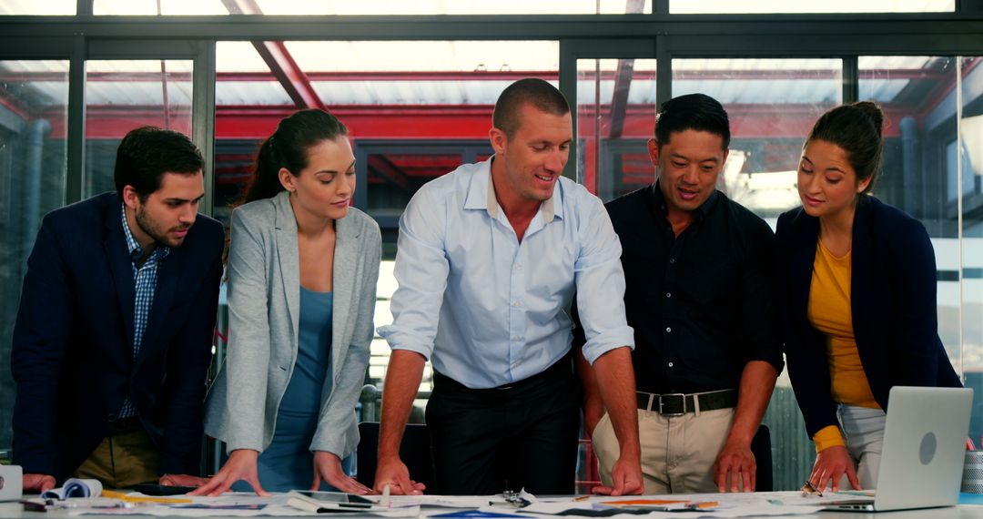 Focused Business Team Collaborating on Project Plan at Modern Workspace