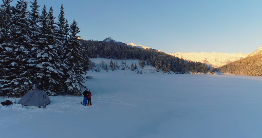 Winter Camping by Snow-Covered Forest and Frozen Lake in Mountainous Landscape - Free Images, Stock Photos and Pictures on Pikwizard.com