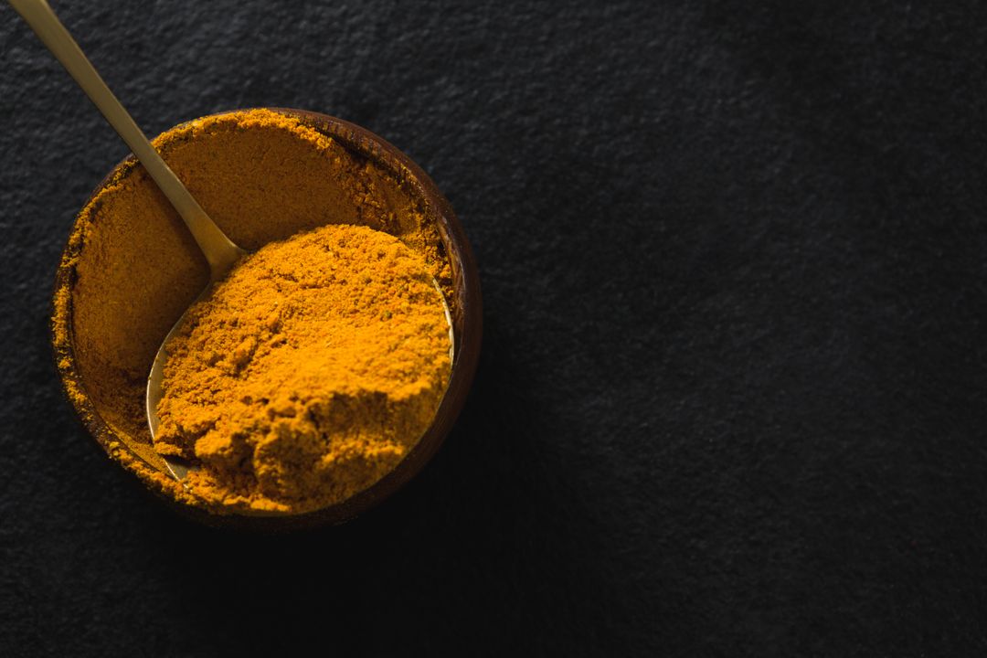 Close-up of Turmeric Powder in Wooden Bowl on Dark Background - Free Images, Stock Photos and Pictures on Pikwizard.com