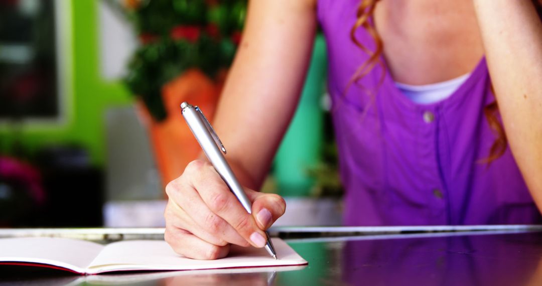 Woman Writing Notes at Desk with Pen in Hand - Free Images, Stock Photos and Pictures on Pikwizard.com