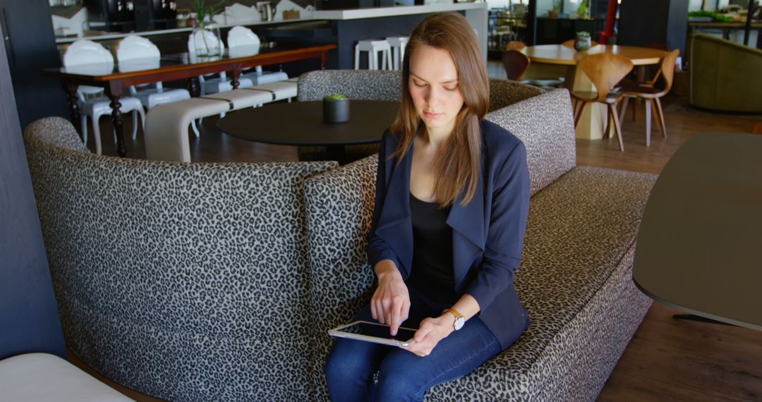 Businesswoman Using Tablet in Modern Office Lounge Area - Free Images, Stock Photos and Pictures on Pikwizard.com