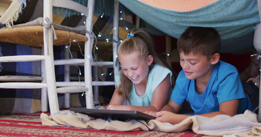 Children Enjoying Digital Tablet in Homemade Blanket Fort - Free Images, Stock Photos and Pictures on Pikwizard.com