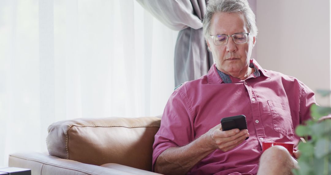 Senior Man Sitting on Couch Using Smartphone - Free Images, Stock Photos and Pictures on Pikwizard.com