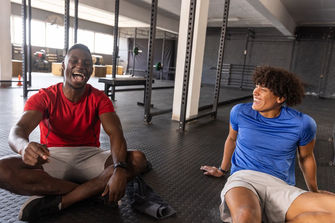 Diverse Friends Laughing Together on Gym Floor After Workout
