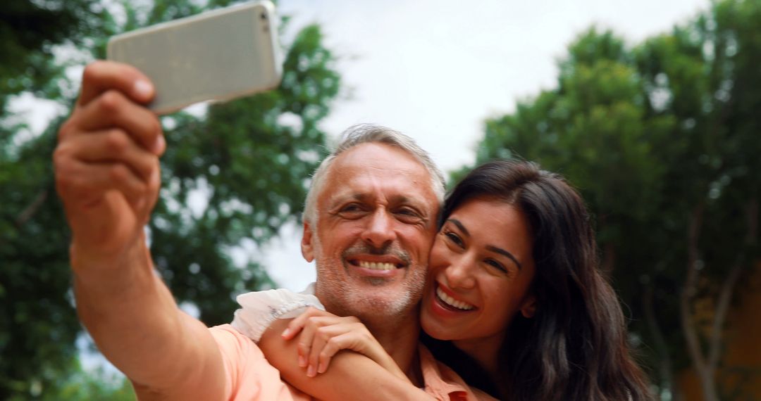 Smiling couple taking selfie together outdoors on sunny day - Free Images, Stock Photos and Pictures on Pikwizard.com