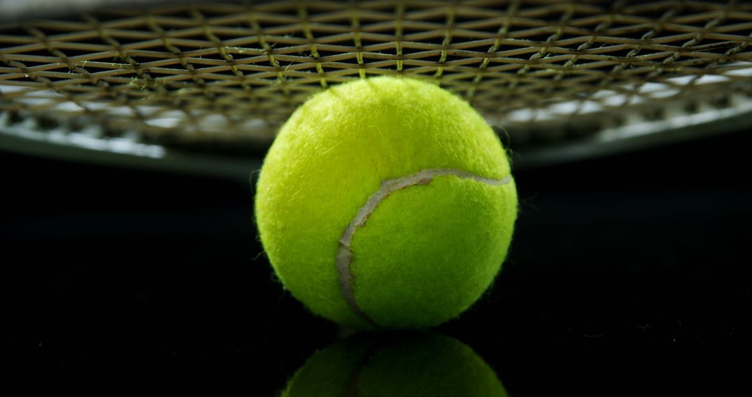 Close-Up of Tennis Ball Under Racket on Black Background - Free Images, Stock Photos and Pictures on Pikwizard.com