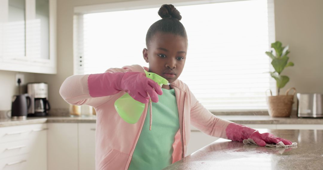 Young African-American Girl Cleaning Kitchen Counter with Spray Bottle - Free Images, Stock Photos and Pictures on Pikwizard.com