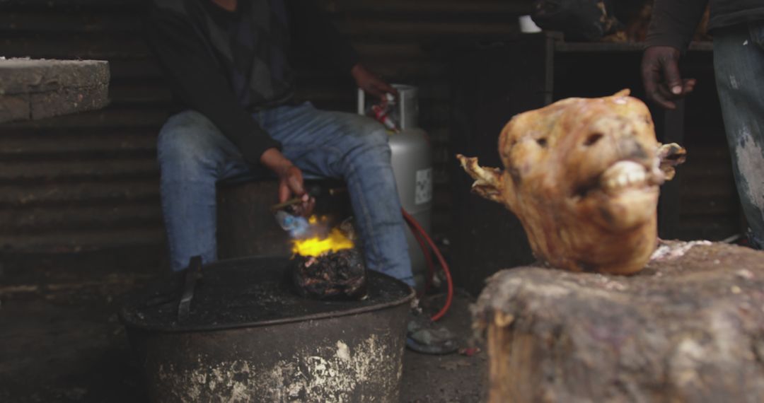 Butcher Preparing Variety Meats Over Flame at Workshop