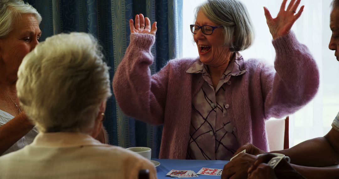 Senior Woman Cheerfully Celebrating During Group Card Game - Free Images, Stock Photos and Pictures on Pikwizard.com