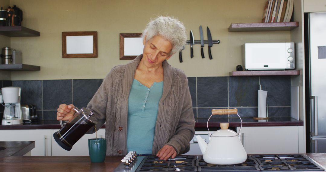 Older Woman Pouring Fresh Coffee in Modern Kitchen - Free Images, Stock Photos and Pictures on Pikwizard.com