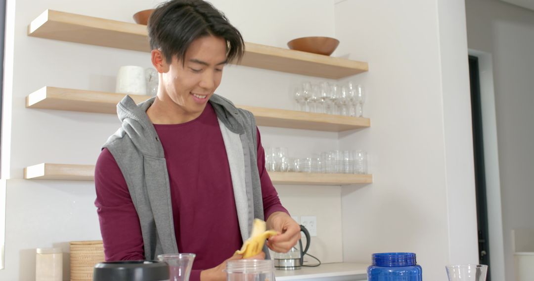 Man Preparing Smoothie in Minimalist Kitchen with Fresh Banana
