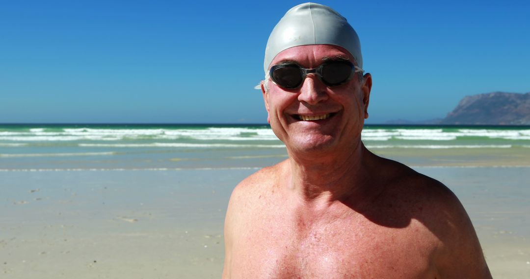 Senior Man Smiling on Sunny Beach Wearing Swimming Cap and Goggles - Free Images, Stock Photos and Pictures on Pikwizard.com