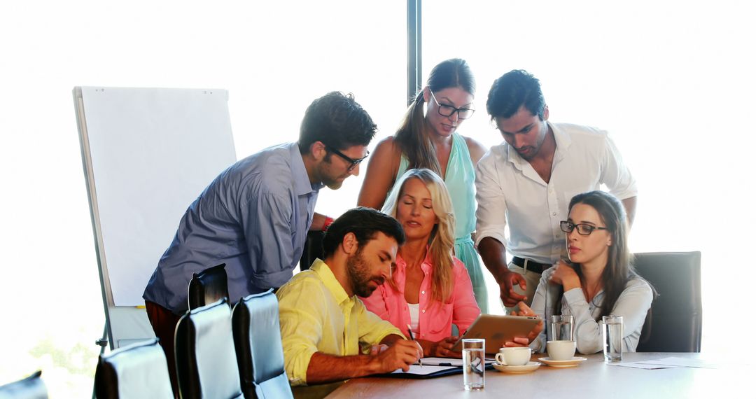 Focused Business Team Discussing Strategy with Tablet in Conference Room