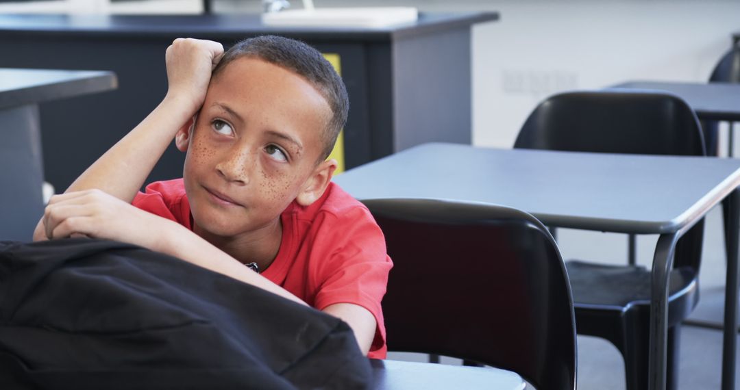Pensive Biracial Boy in Classroom Thinking