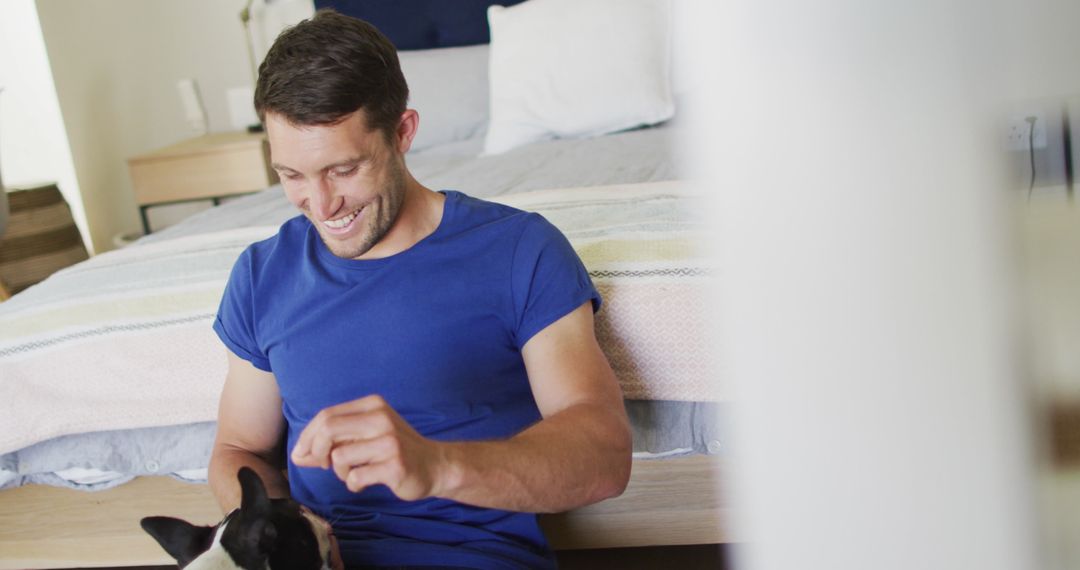 Man Relaxing at Home and Playing with French Bulldog