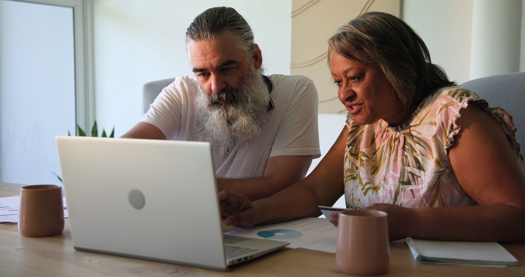 Senior Couple Engaged in Discussion with Laptop at Home