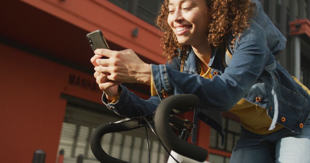 Cheerful Woman Riding Bike While Using Smartphone - Free Images, Stock Photos and Pictures on Pikwizard.com