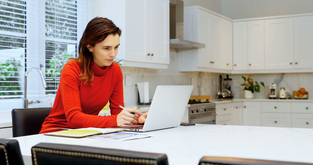 Young Woman Working on Laptop at Kitchen Table - Free Images, Stock Photos and Pictures on Pikwizard.com