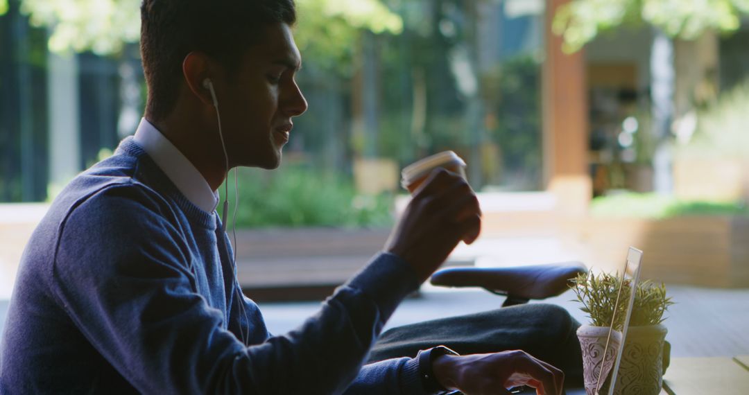 Man Relaxing with Coffee and Laptop in Urban Setting
