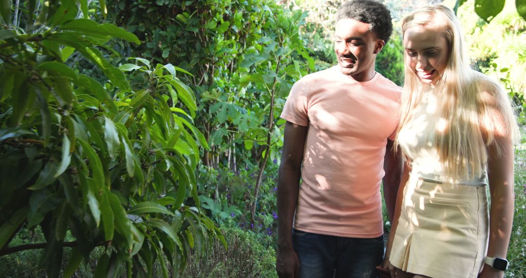 Diverse Couple Exploring Lush Garden with Smartwatch on Display