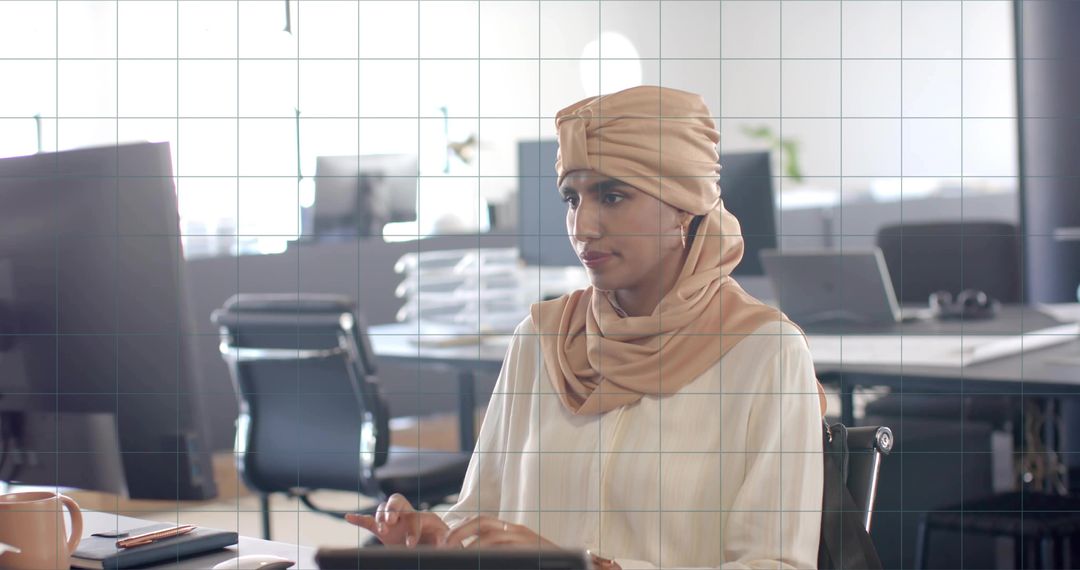 Indian woman with headscarf working at modern office desk