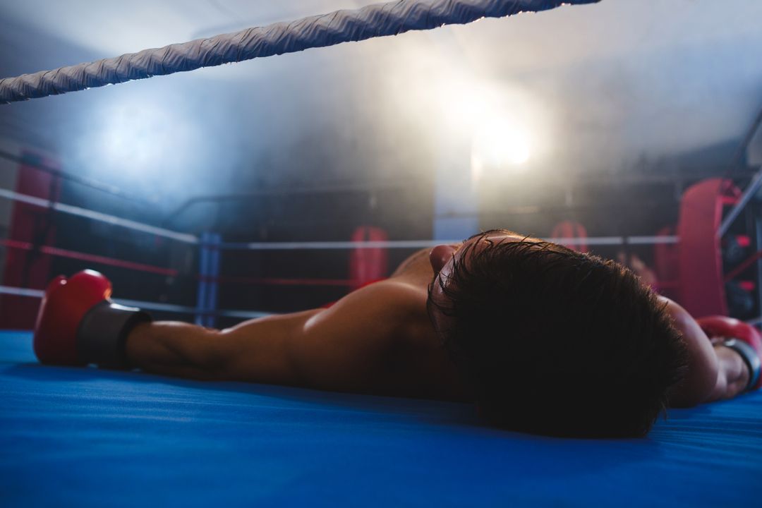 Boxer in Glove Collapse Under Hazy Gym Lights After Match