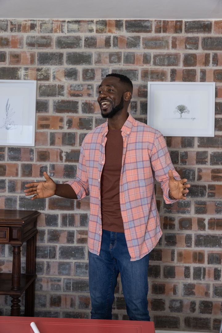 Smiling Man by Rustic Brick Wall Ensuring Warm Welcome
