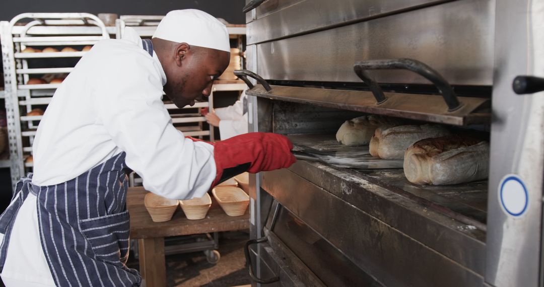 Professional Baker Checking Freshly Baked Bread in Industrial Oven - Free Images, Stock Photos and Pictures on Pikwizard.com