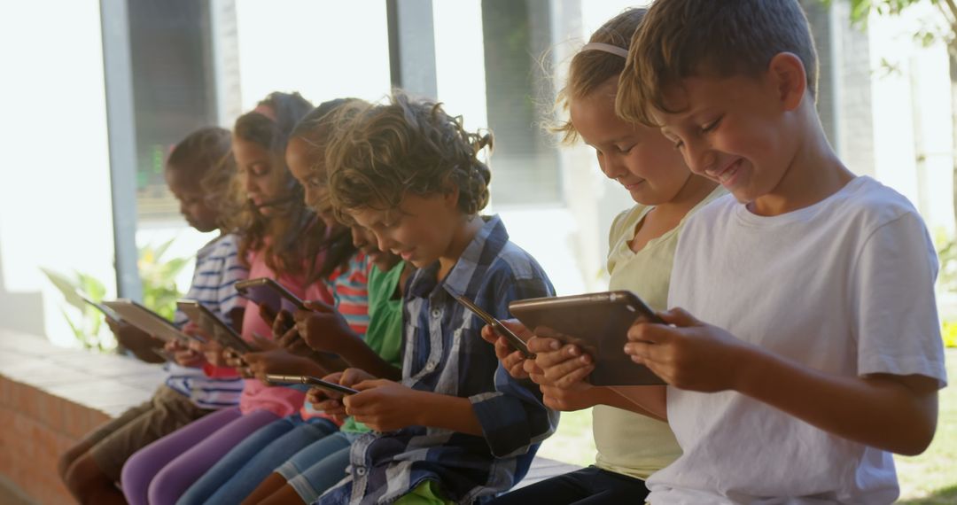 Smiling Young Students Using Tablets in Outdoor Classroom