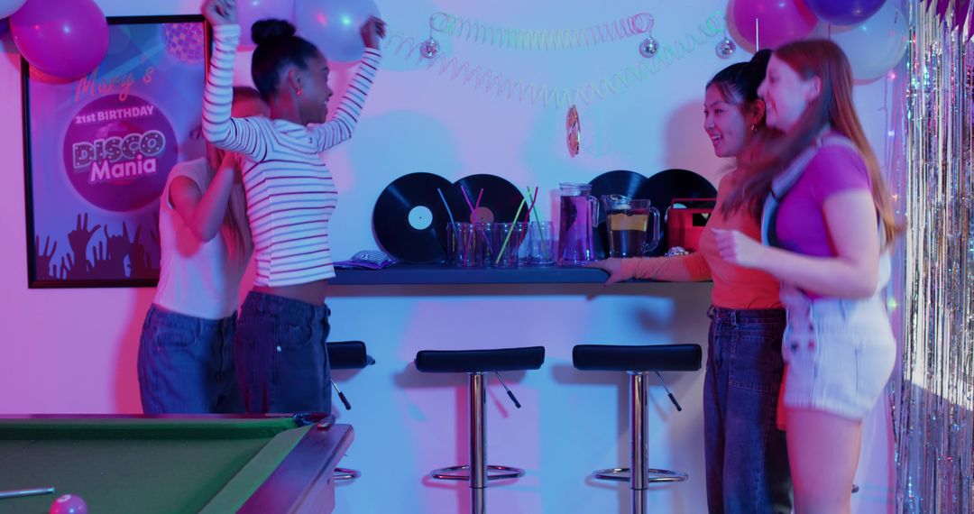 Friends dancing at disco-themed home party with pool table, vinyl records and balloons
