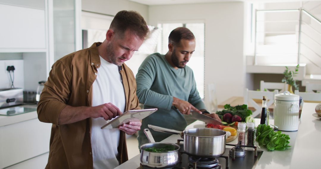 Two Men Cooking Together in Modern Kitchen Using Tablet for Recipes - Free Images, Stock Photos and Pictures on Pikwizard.com