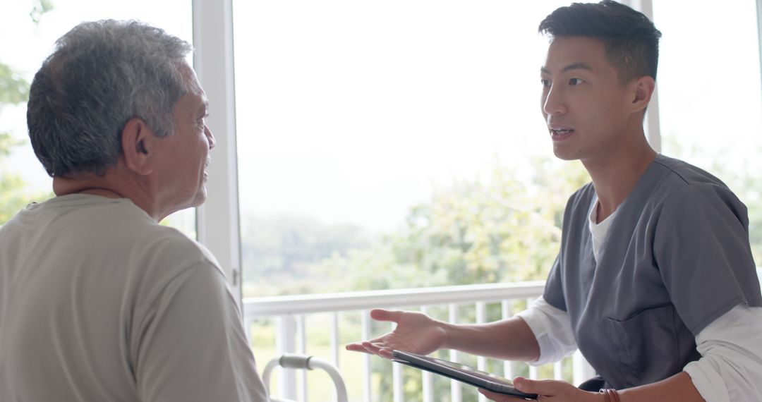 Young Healthcare Worker Discussing with Senior Man in Hospital - Free Images, Stock Photos and Pictures on Pikwizard.com