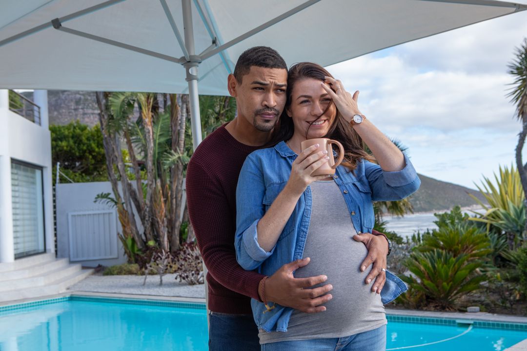 Joyful Expectant Couple Embracing by Poolside