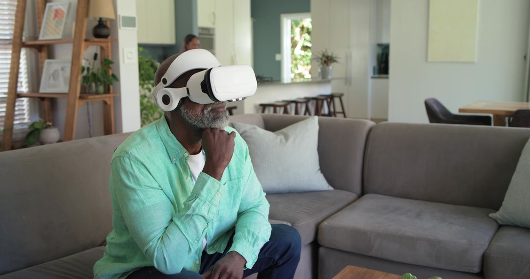Senior African American Man Exploring Virtual Reality at Home on Modern Gray Sofa