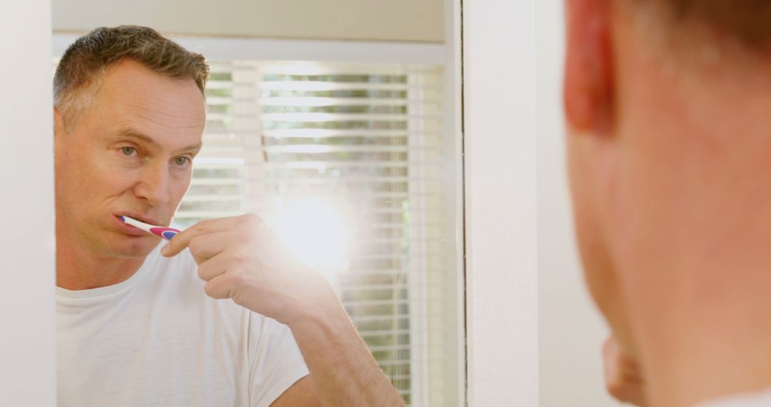 Man Brushing Teeth in Bathroom Mirror in Morning - Free Images, Stock Photos and Pictures on Pikwizard.com