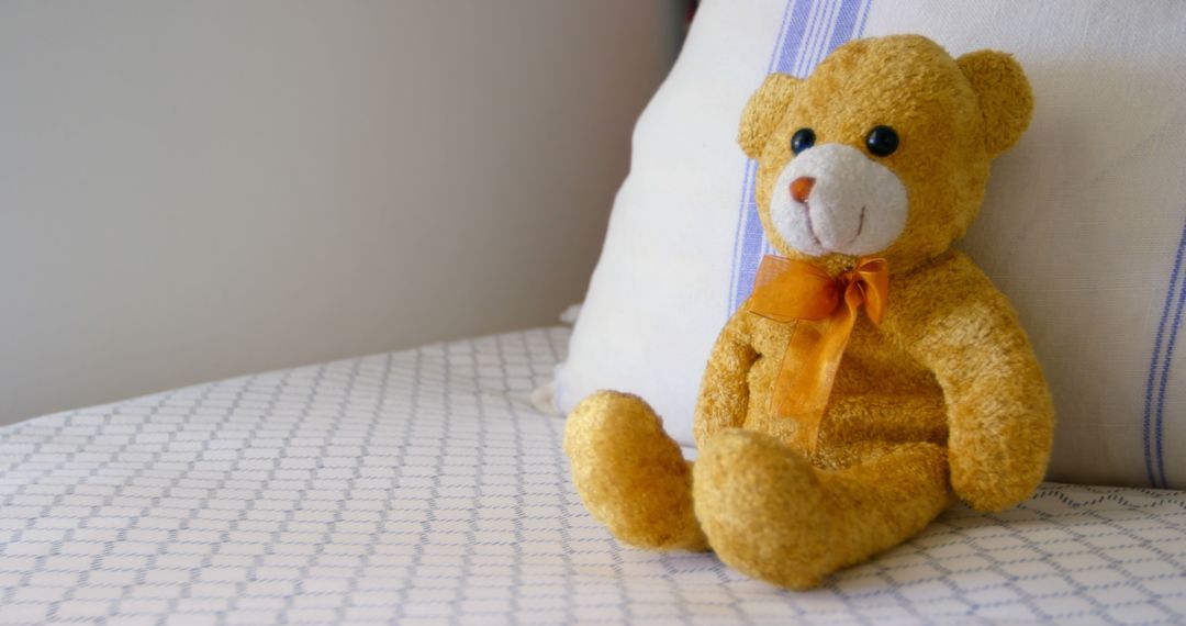 Cute Teddy Bear Sitting on Bed Near Pillow in Cozy Bedroom - Free Images, Stock Photos and Pictures on Pikwizard.com