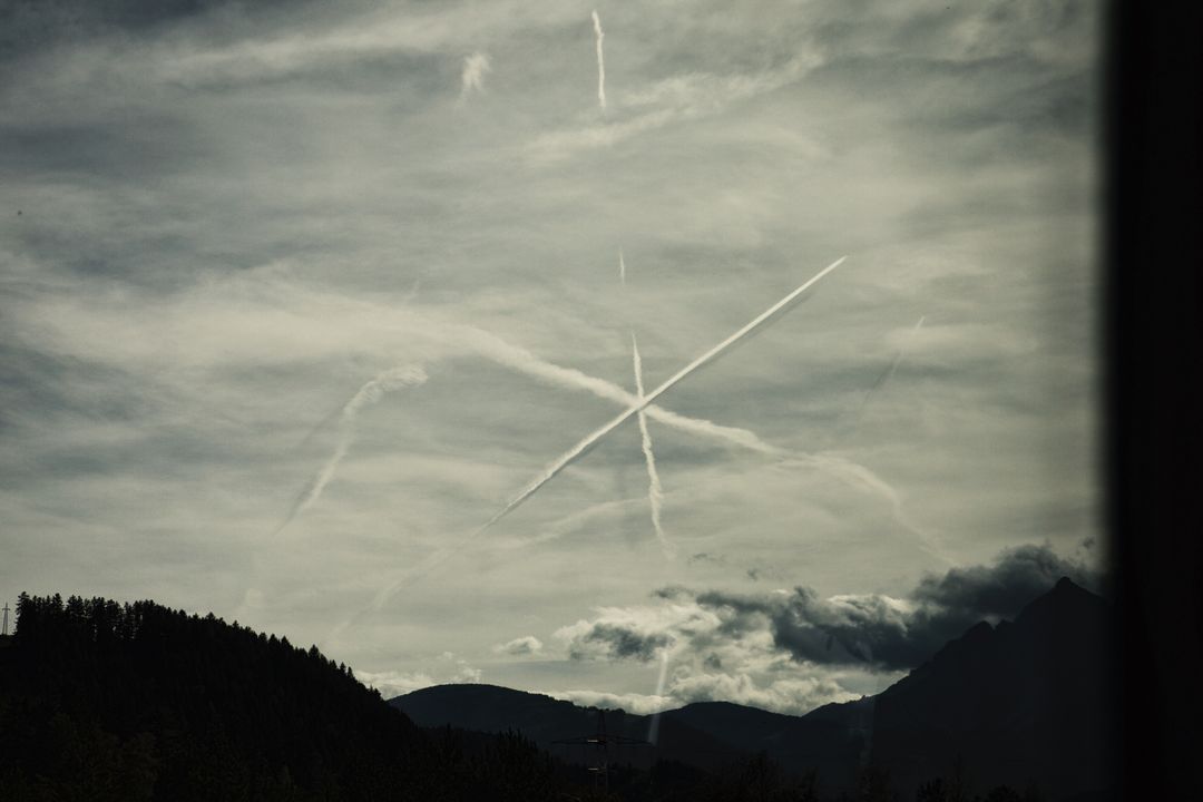 Mountain Skyline with Contrail Patterns in Cloudy Sky - Free Images, Stock Photos and Pictures on Pikwizard.com