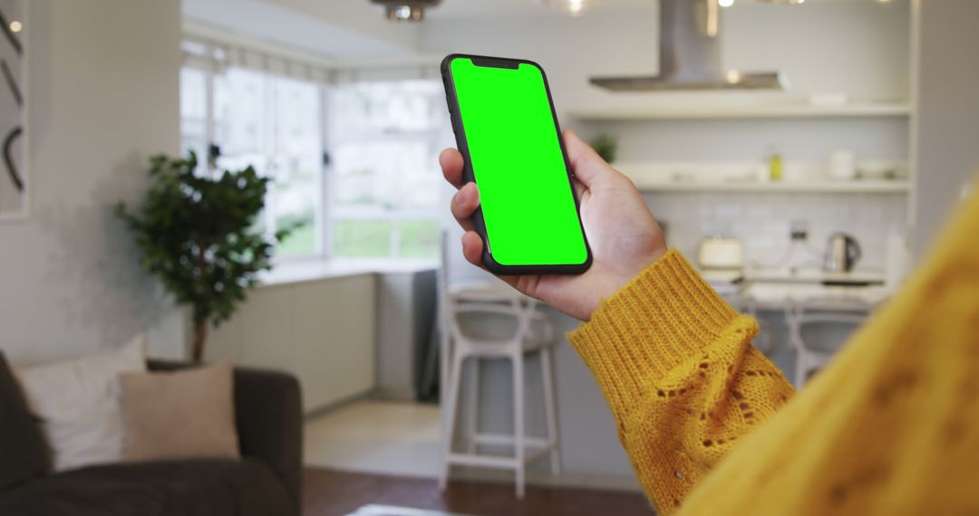 Hand Holding Smartphone with Green Screen in Modern Kitchen - Free Images, Stock Photos and Pictures on Pikwizard.com