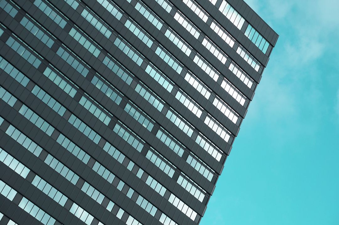Modern condo skyscraper with reflections against bright sky